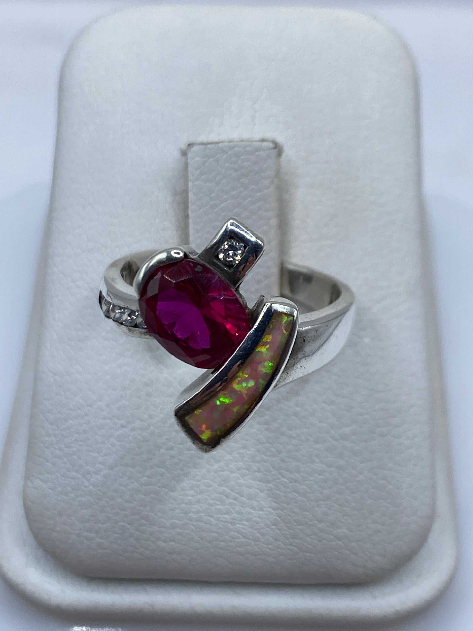 Anillo de plata con ópalo de fuego rosa en la mano de una mujer