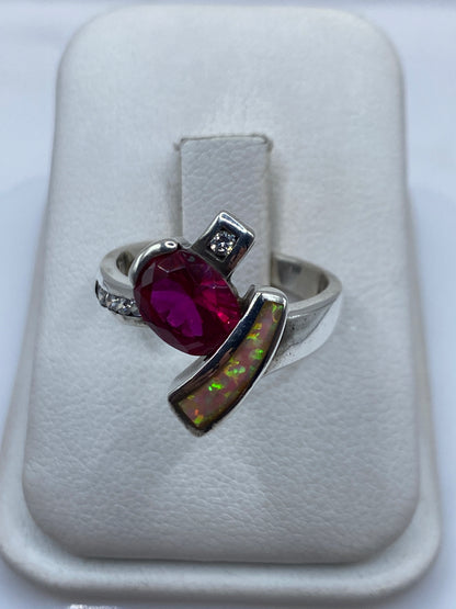 Anillo de plata con ópalo de fuego rosa en la mano de una mujer