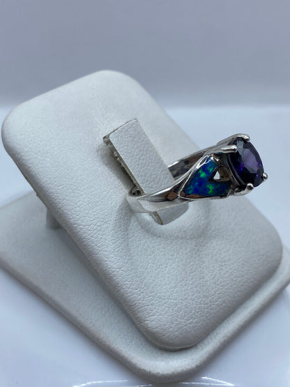 Vista lateral del anillo mostrando el engaste a mano y el juego de colores azul y verde del ópalo