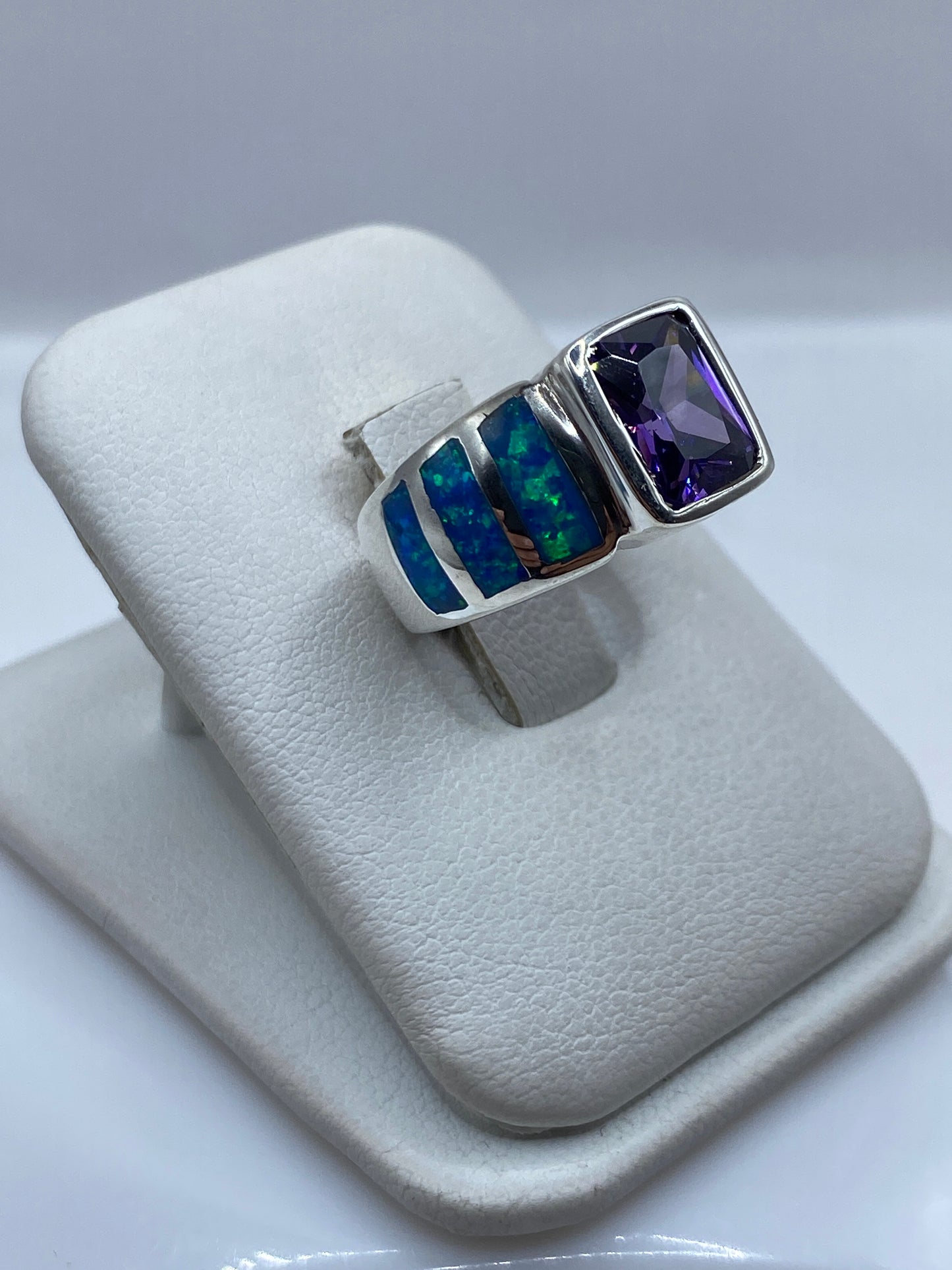 Ópalo de fuego azul y verde en anillo de plata, mostrando el juego de color intenso desde el lateral