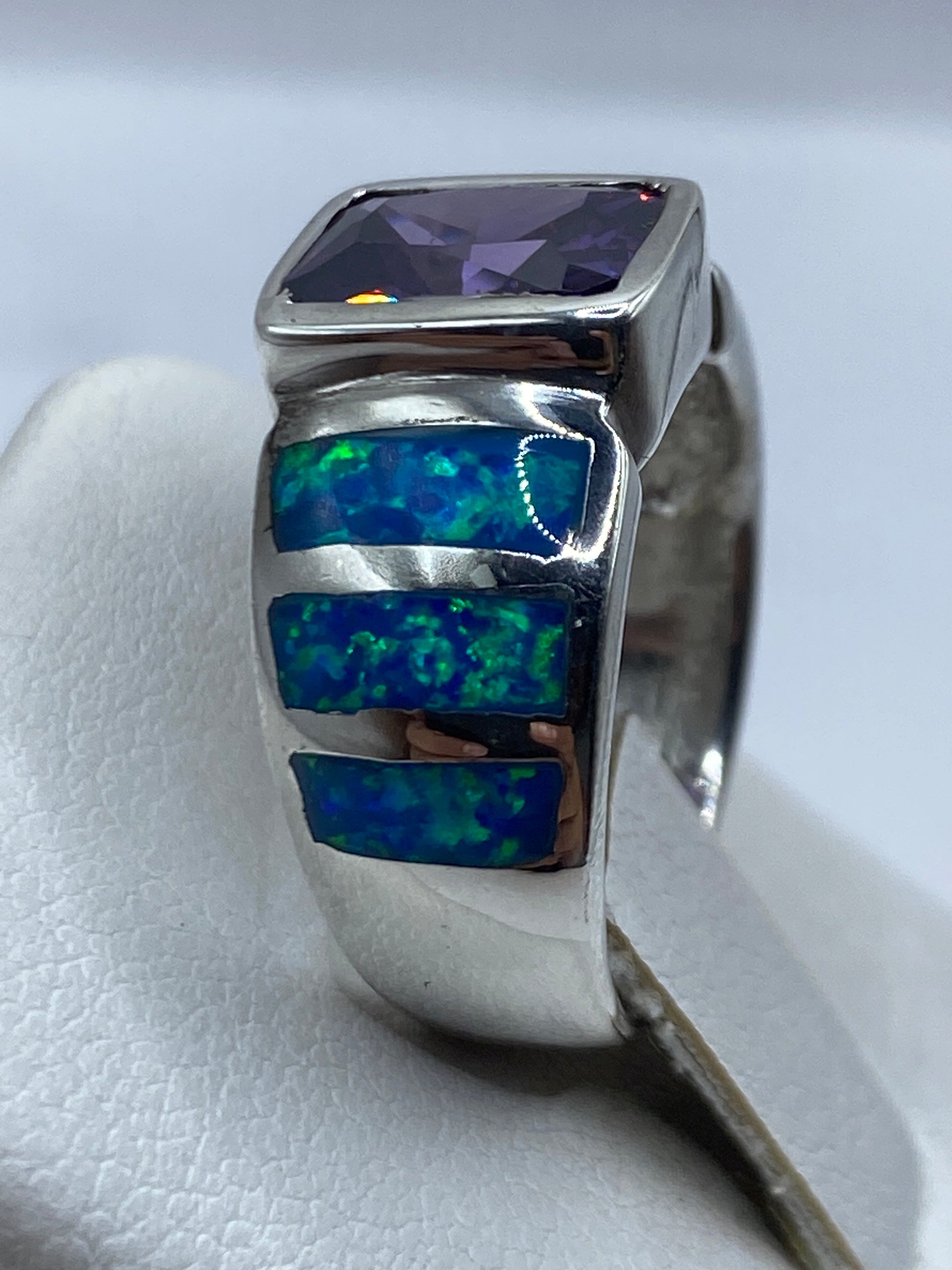 Anillo geométrico en plata Taxco con incrustaciones azules y ópalo central, en la mano de una persona