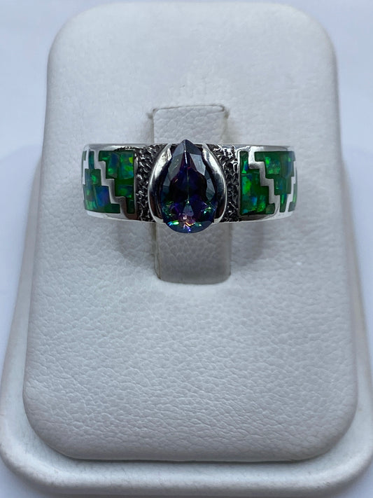 Anillo de plata .950 con ópalo de fuego verde limón y motivos prehispánicos en la mano de una persona