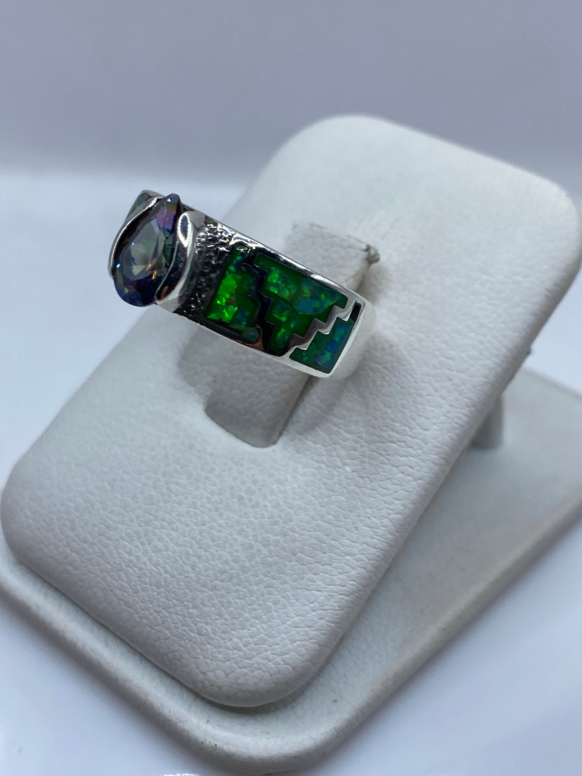 Vista frontal del anillo prehispánico mostrando el juego de color verde y naranja del ópalo de fuego