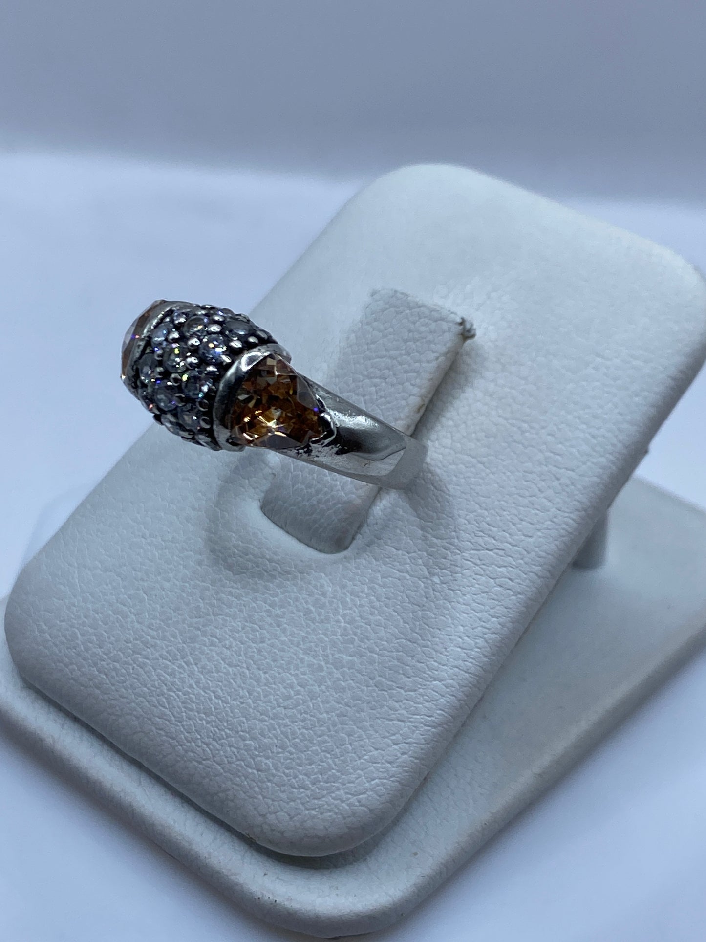 Detalle lateral del anillo mostrando los facetados dorados y la piedra café
