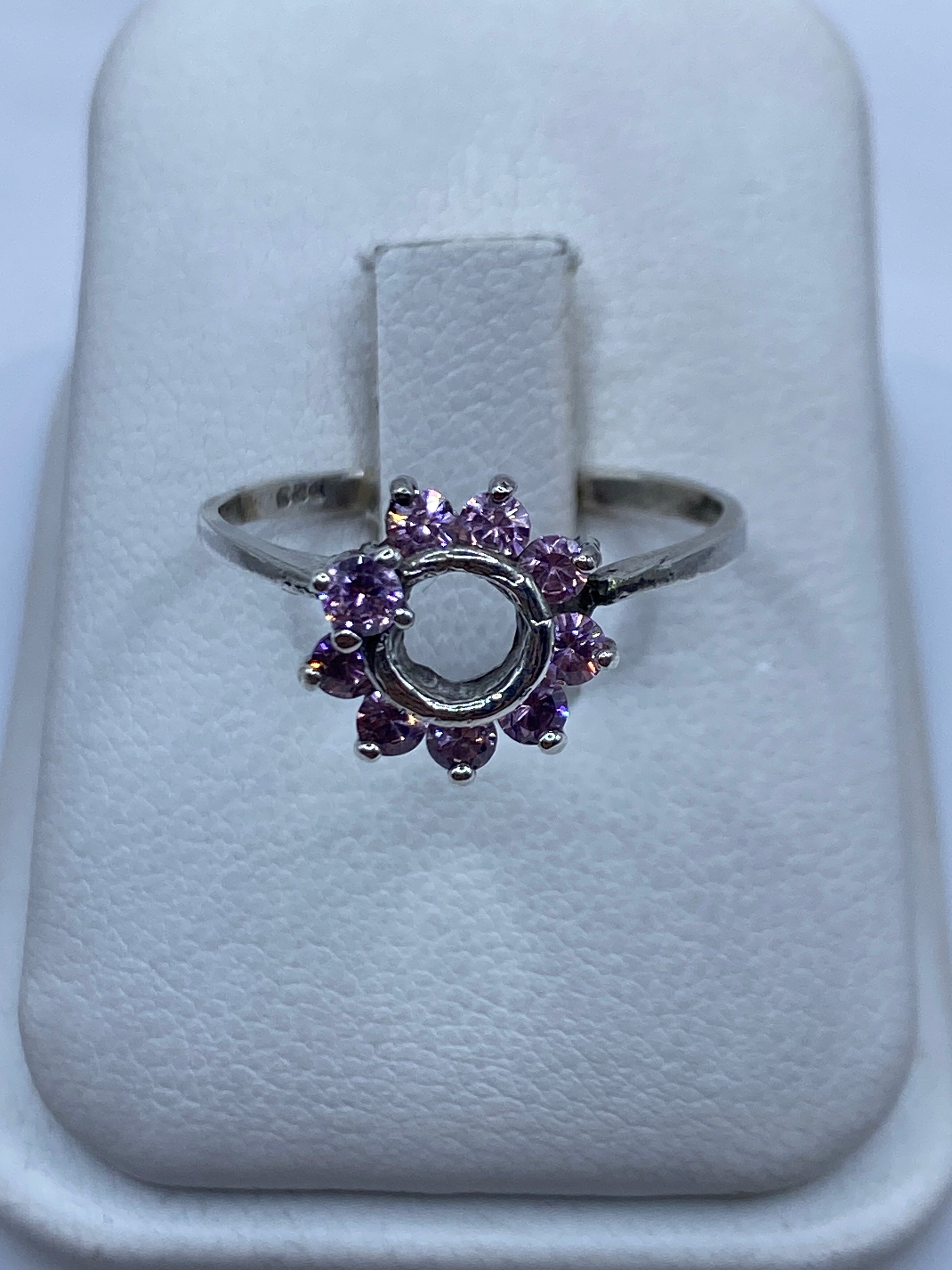 Anillo de plata solitario con circonia rosa brillante en la mano de una mujer
