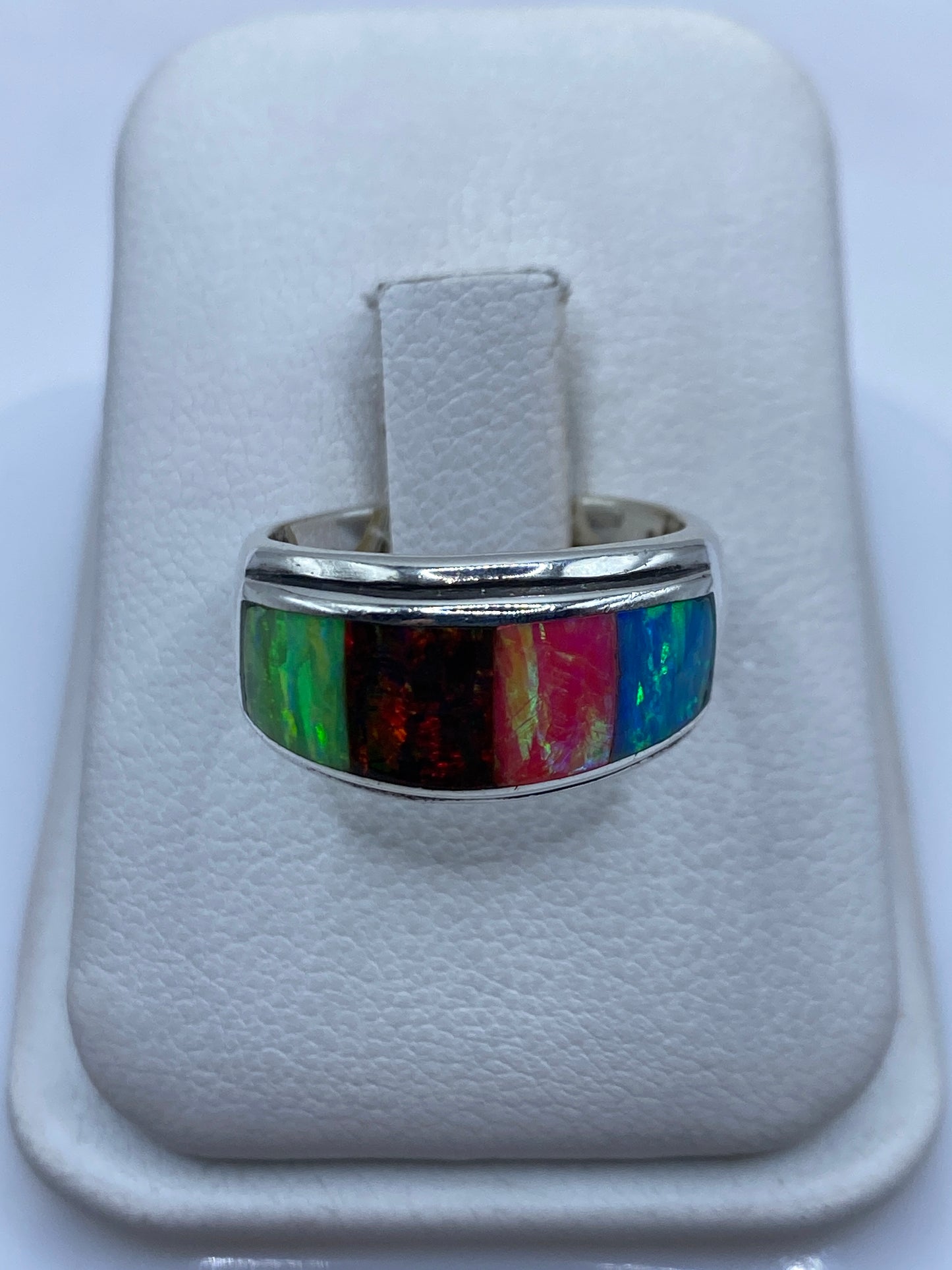 Anillo solitario de ópalo de fuego multicolor en plata .950, mostrando verde, rojo y naranja bajo luz natural