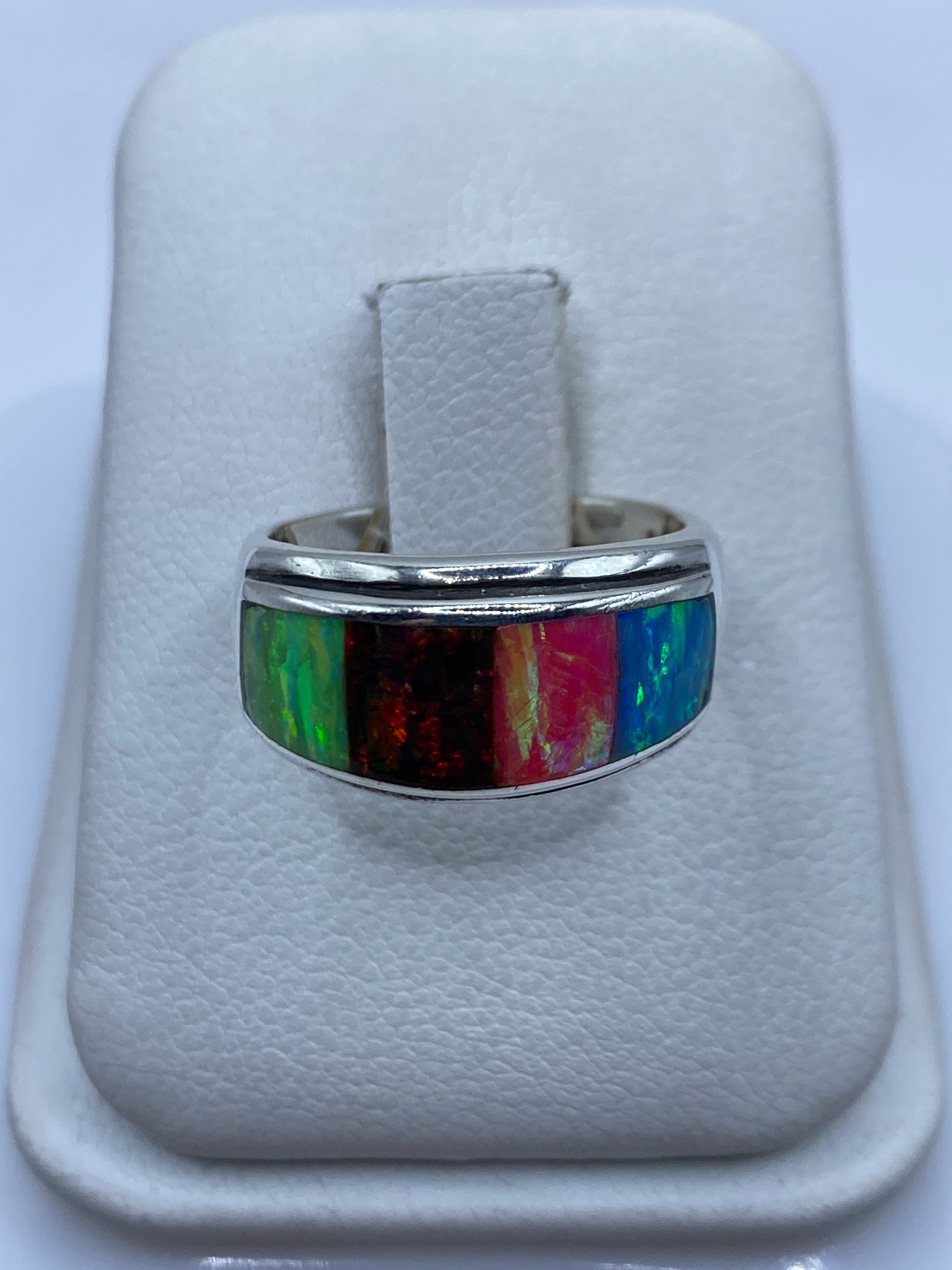 Anillo solitario de ópalo de fuego multicolor en plata .950, mostrando verde, rojo y naranja bajo luz natural