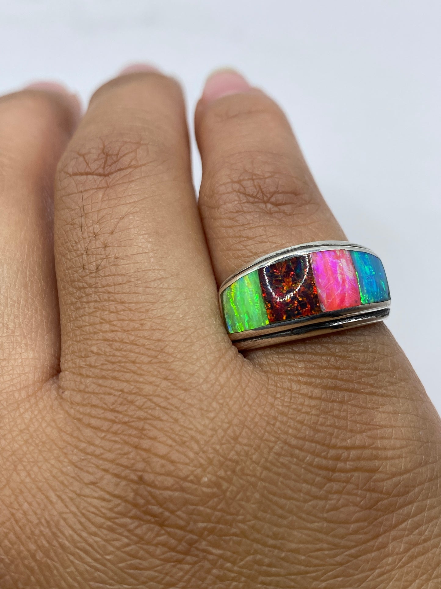 Anillo sobre fondo neutro mostrando el sello 950 y el fuego del ópalo brillante