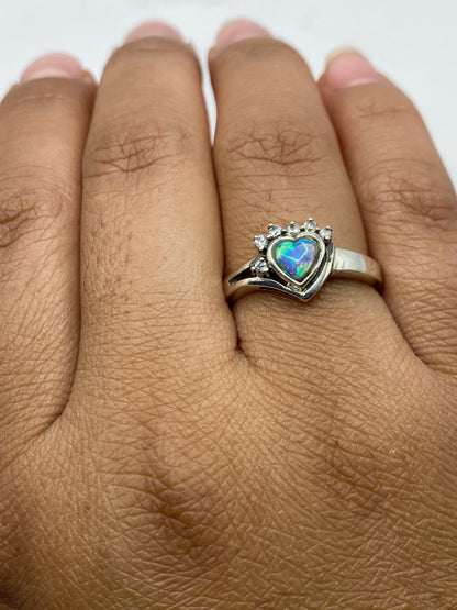 Anillo de ópalo azul cielo con circonias en la mano, mostrando el fuego natural de la piedra