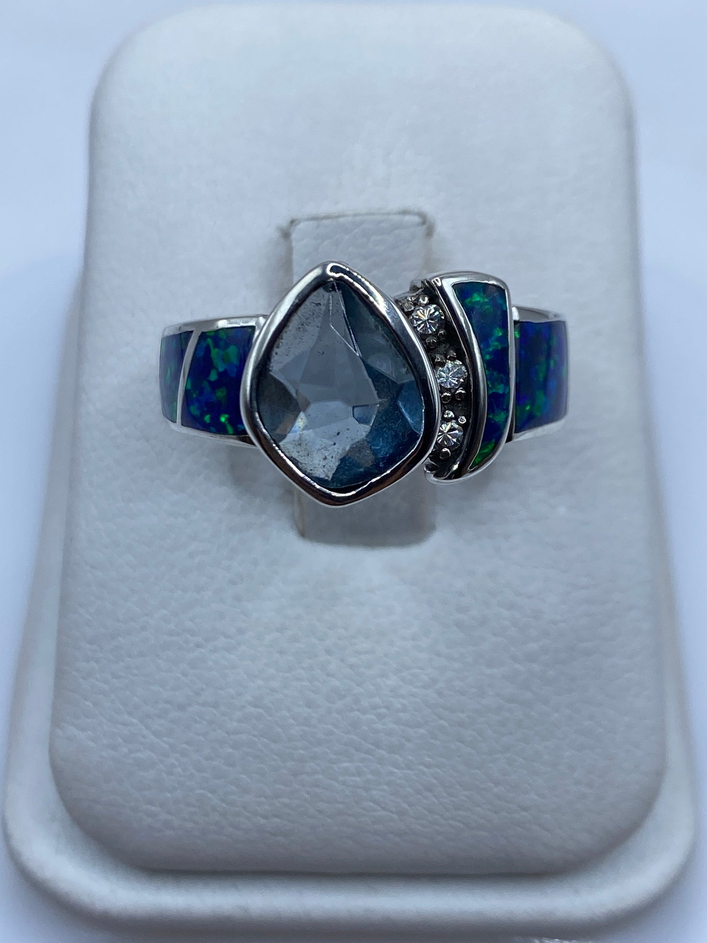 Anillo de plata con ópalo de fuego azul mostrando juego cromático en luz natural