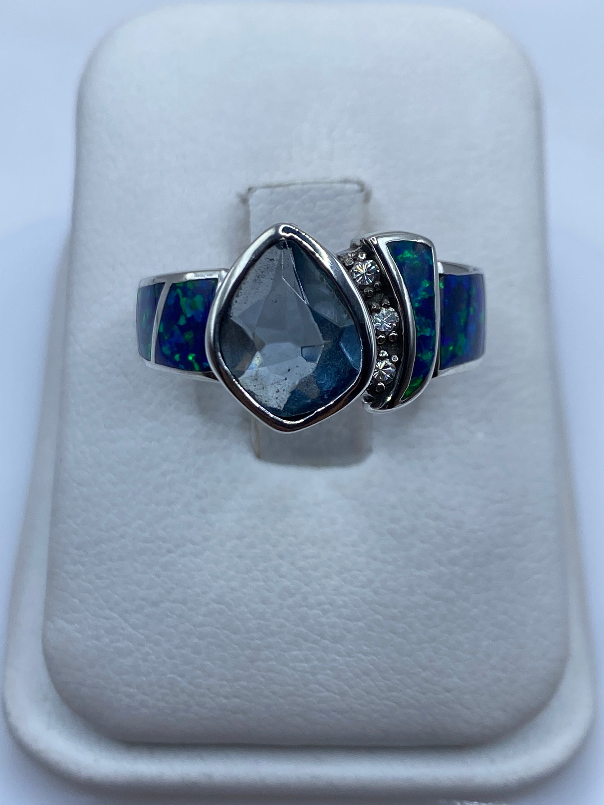 Anillo de plata con ópalo de fuego azul mostrando juego cromático en luz natural