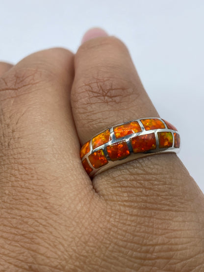 Anillo de plata .950 con sello visible, portado en mano mostrando el juego de colores del ópalo