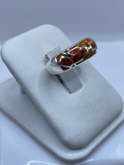 Detalle del ópalo de fuego mostrando juego de colores naranja y amarillo en la mano