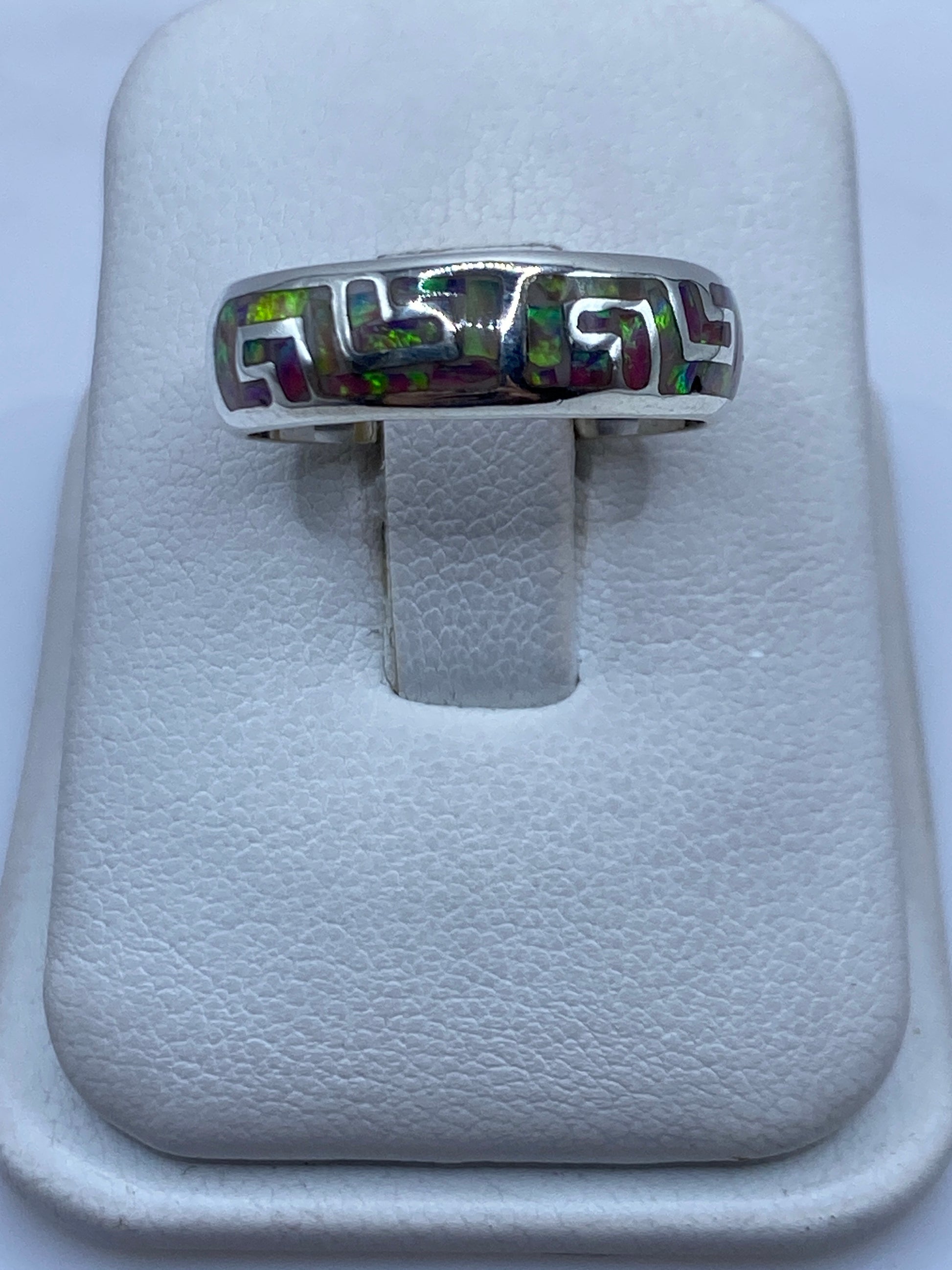 Anillo de plata .950 con ópalo de fuego multicolor sostenido en la mano