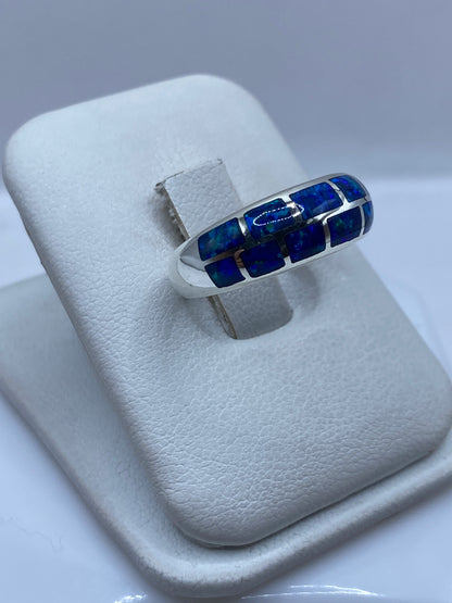 Detalle del ópalo de fuego mostrando juego de colores azul y verde en anillo de plata pura