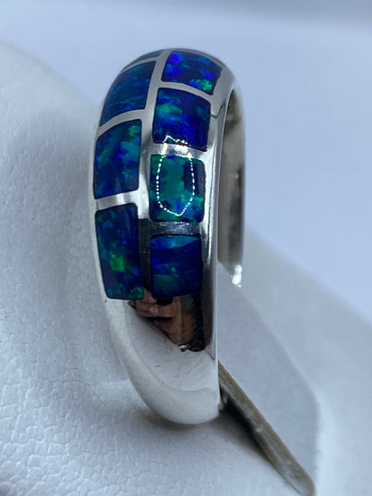 Anillo de plata moderno con ópalo en la mano, vista lateral con diseño minimalista