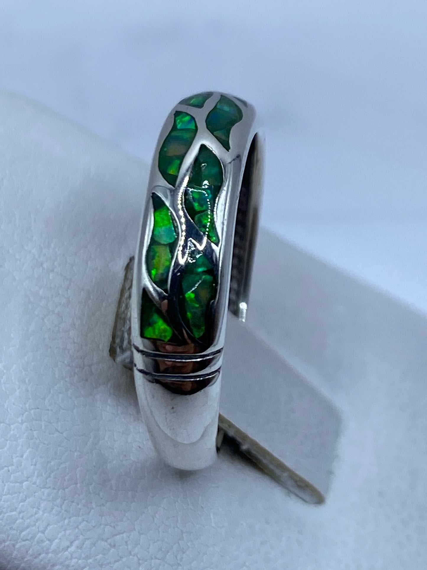 Anillo de ópalo de fuego verde puesto en dedo, mostrando el fuego natural