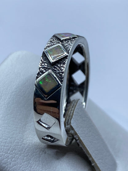 Anillo unisex con textura martillada y ópalo multicolor puesto en mano