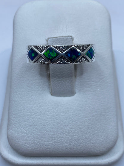 Anillo de plata .950 con ópalo de fuego azul y verde, vista frontal sobre estuche blanco
