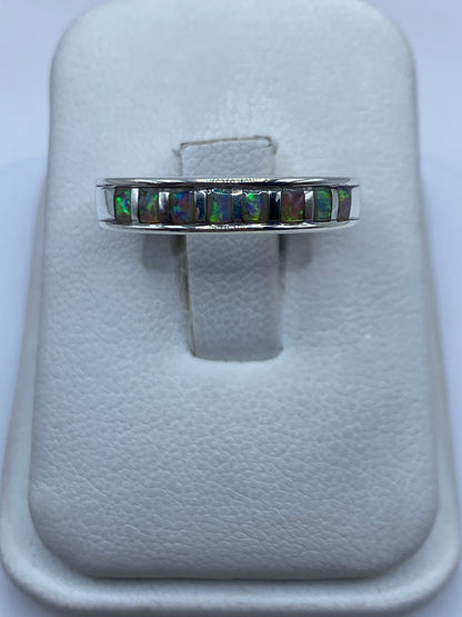 Anillo de plata con ópalo de fuego multicolor mostrando juego de luz verde y naranja