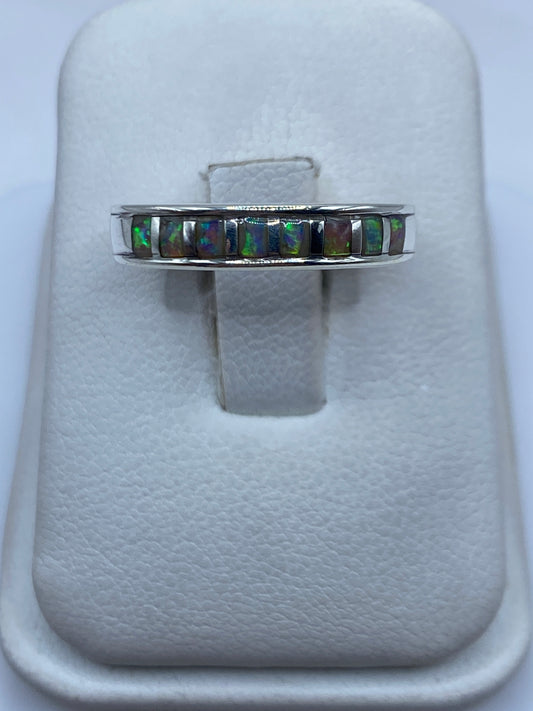 Anillo de plata con ópalo de fuego multicolor mostrando juego de luz verde y naranja