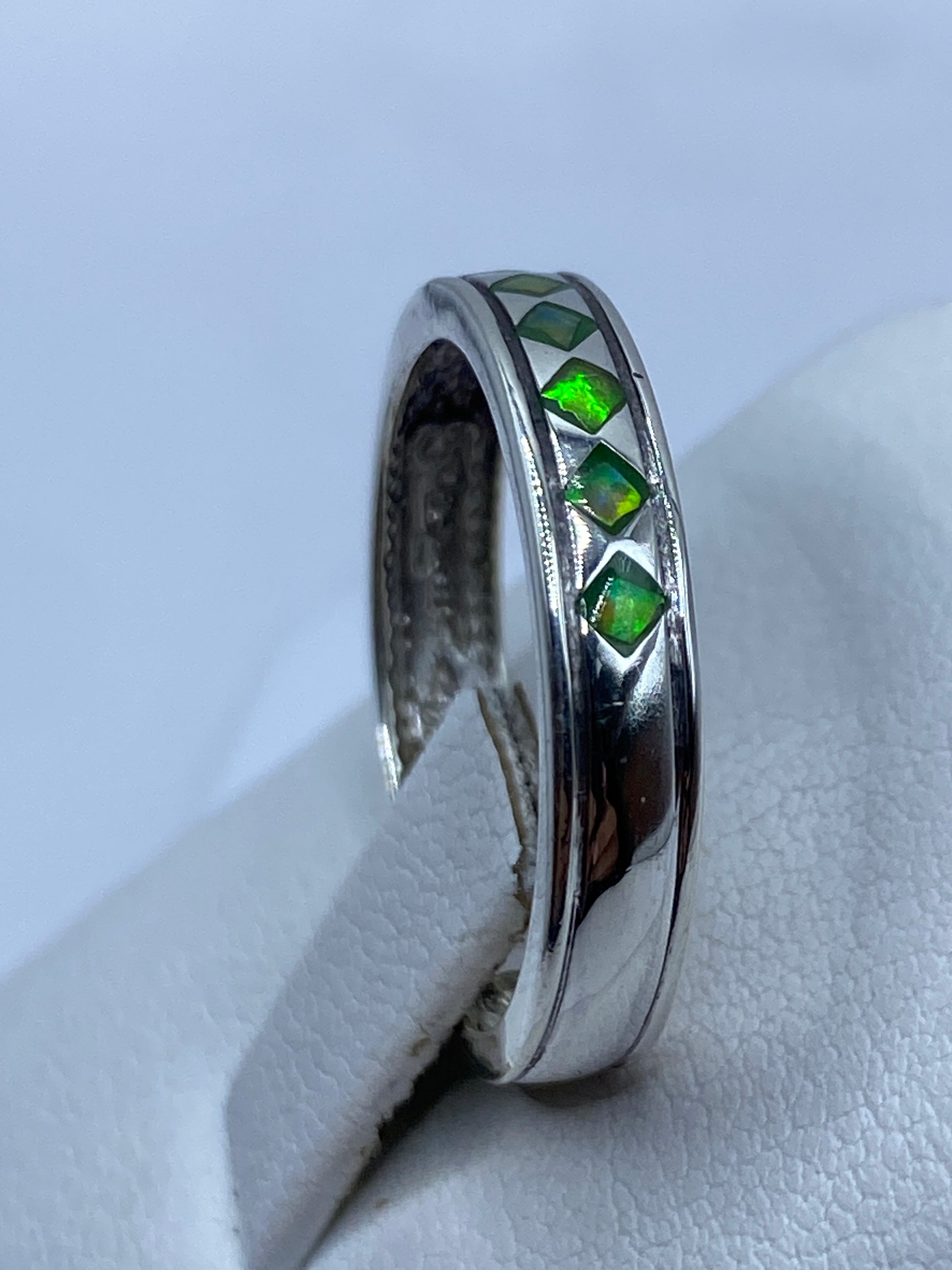 Anillo visto desde el lateral mostrando el pulido y el brillo del ópalo