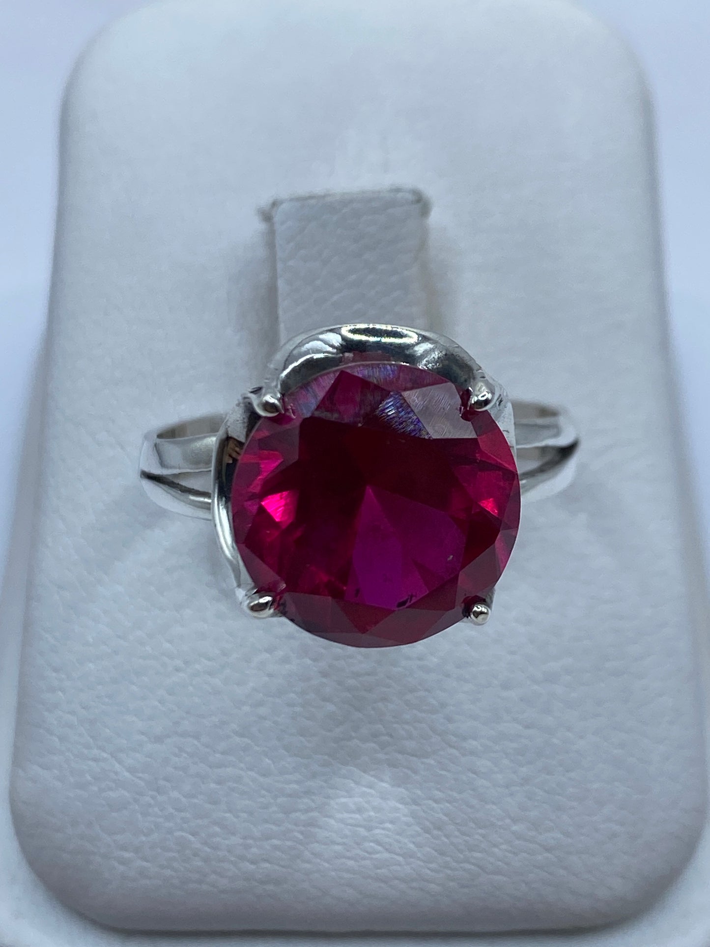 Anillo de plata solitario con circonia rosa redonda en la mano de una mujer