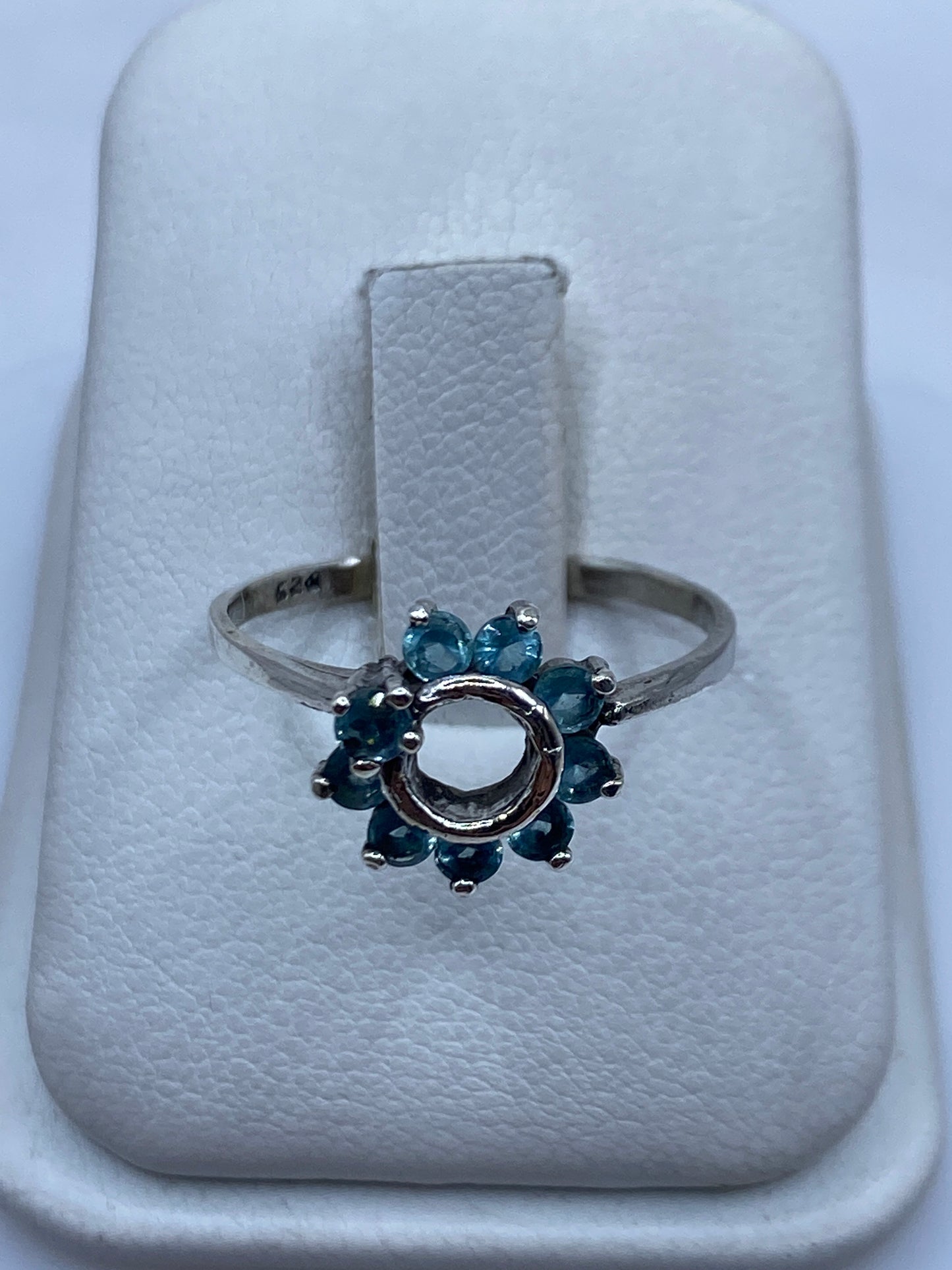 Anillo solitario de plata con circonia azul cielo en la mano de una mujer