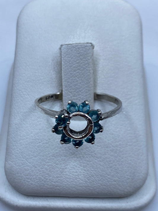 Anillo solitario de plata con circonia azul cielo en la mano de una mujer