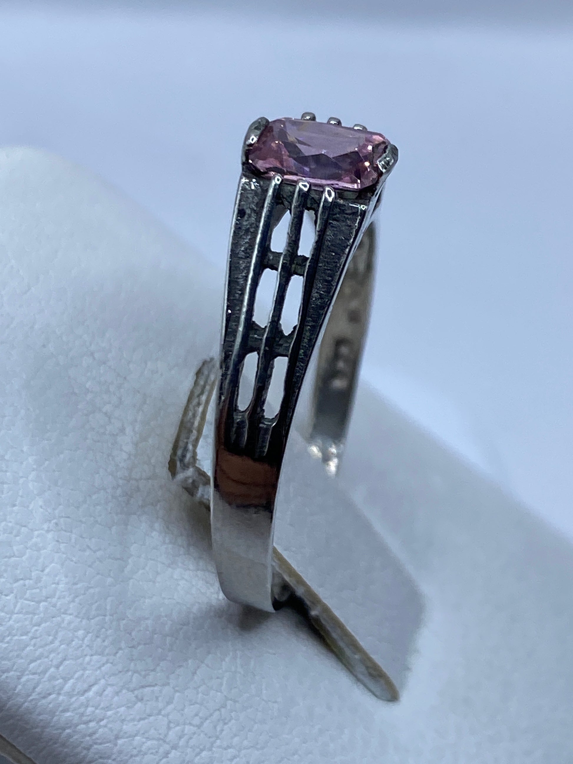 Anillo solitario circonia rosa en dedo, mostrando brillo y proporciones