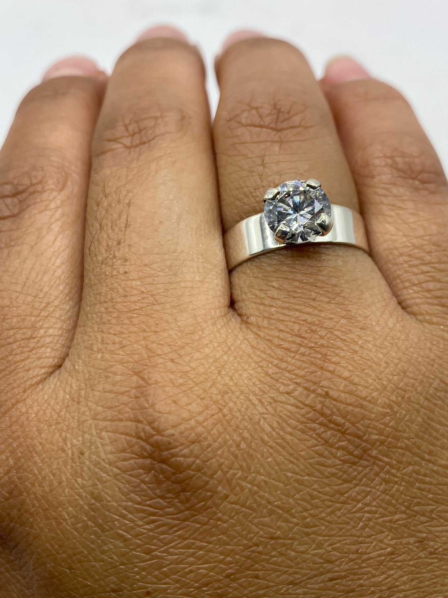 Anillo solitario sobre fondo gris mostrando el sello 925 y la elegancia de la pieza