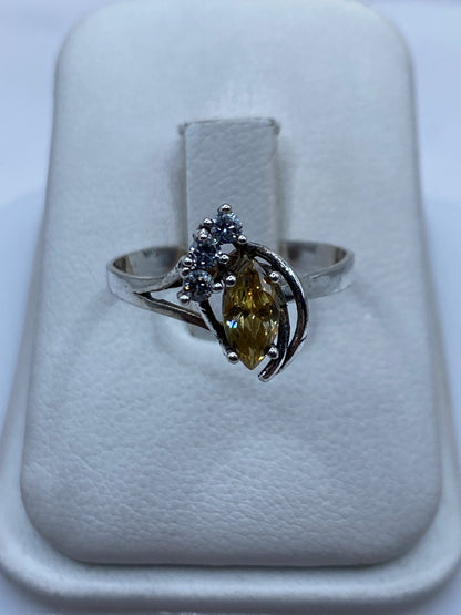 Anillo de plata solitario con circonia café facetada en la mano de una mujer