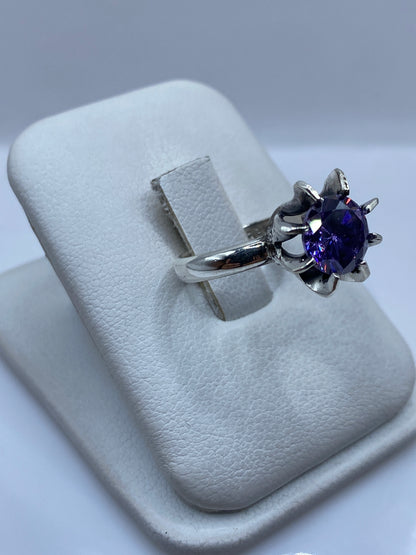 Detalle lateral del anillo morado en plata, mostrando el pulido espejo y el engaste a mano