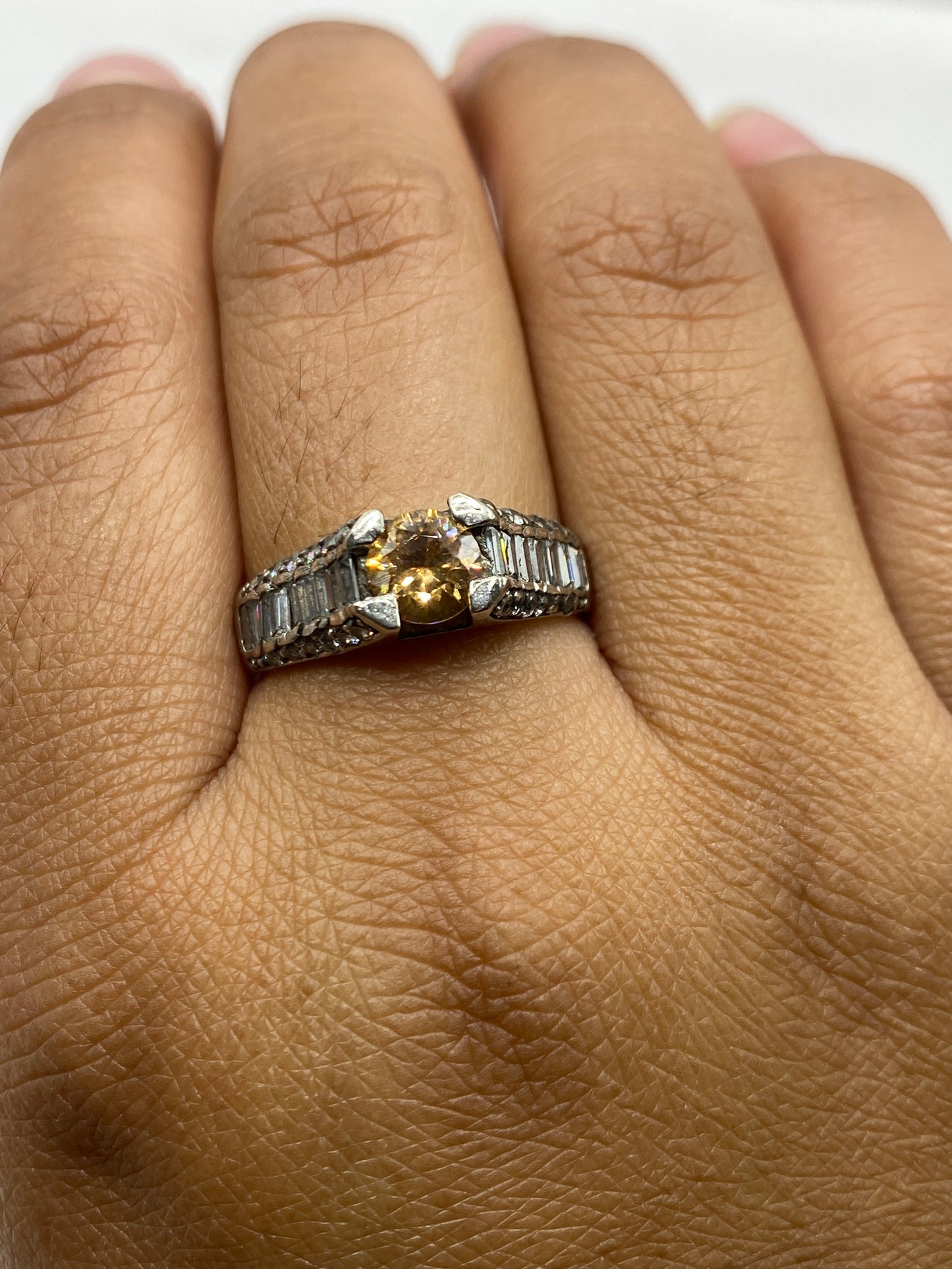 Anillo solitario sobre fondo gris mostrando el sello 925 en la banda interior