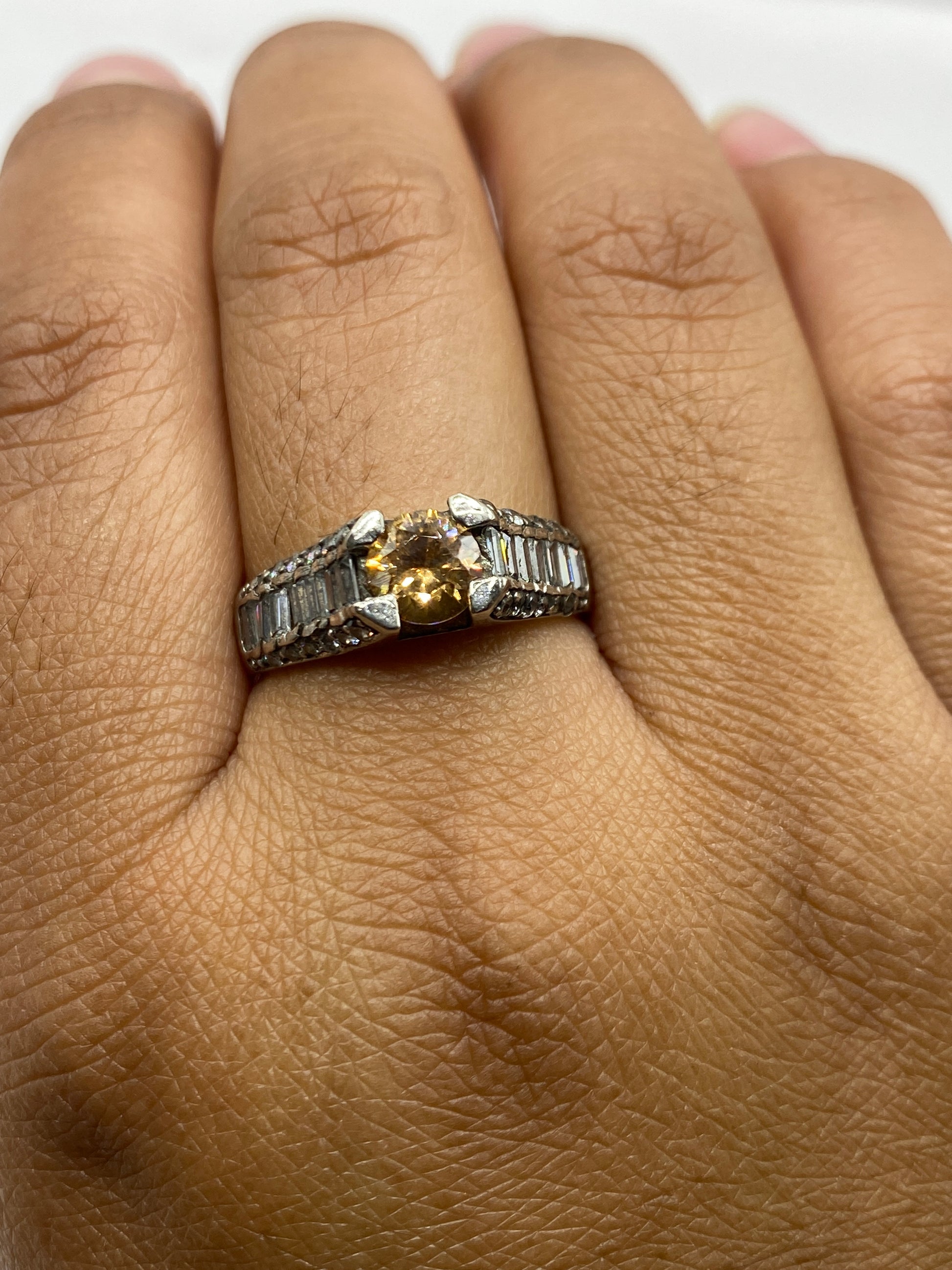 Anillo solitario sobre fondo gris mostrando el sello 925 en la banda interior