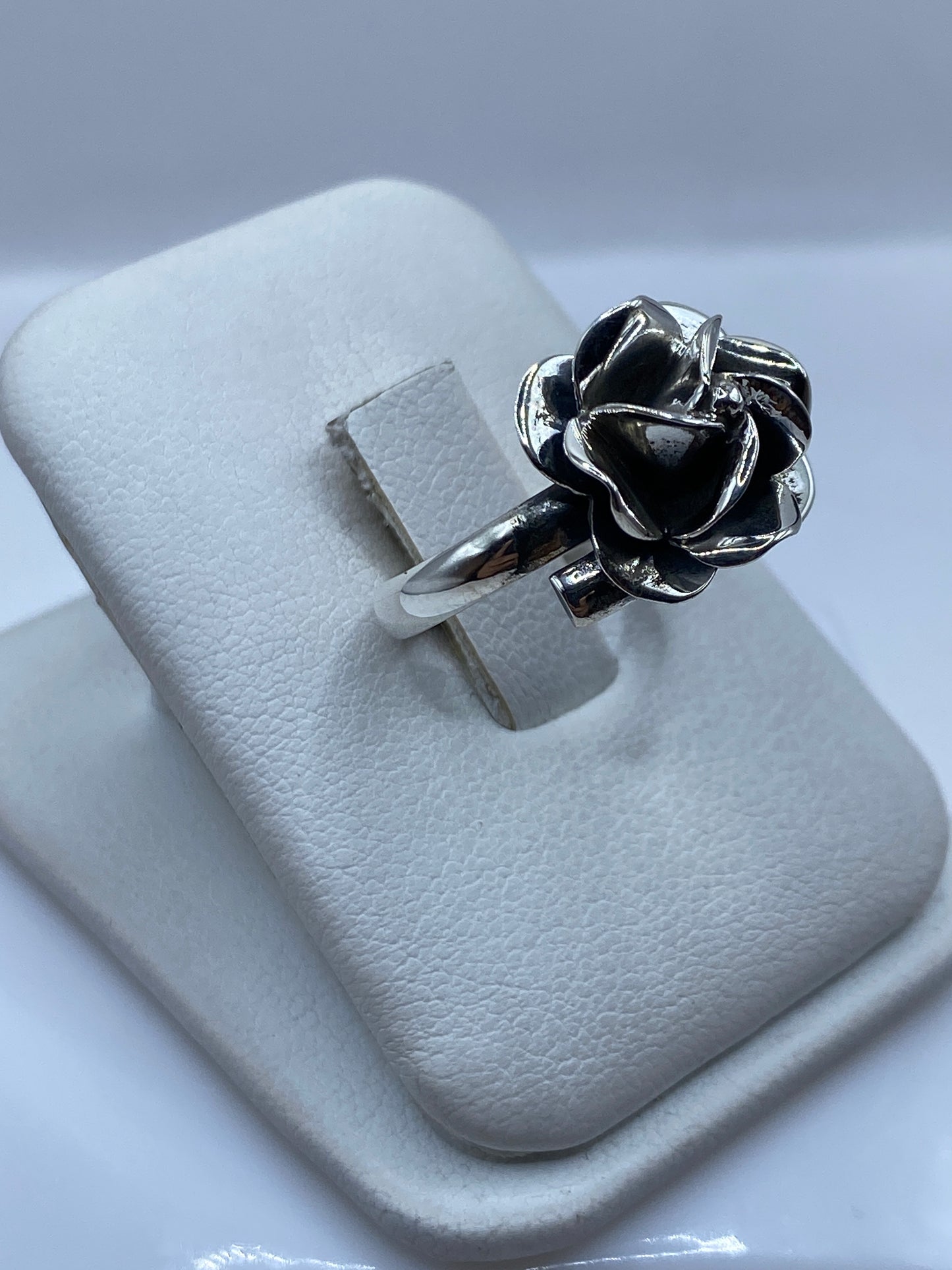 Anillo rosa en plata vista lateral en dedo, mostrando los pétalos en movimiento