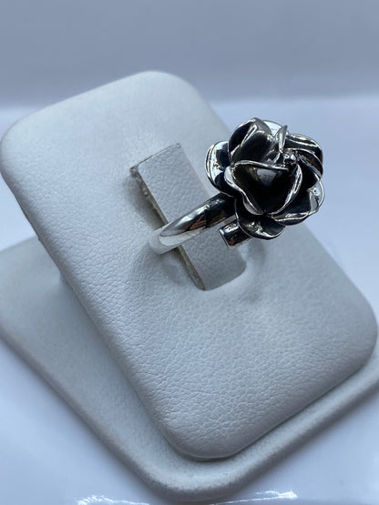Anillo rosa en plata vista lateral en dedo, mostrando los pétalos en movimiento
