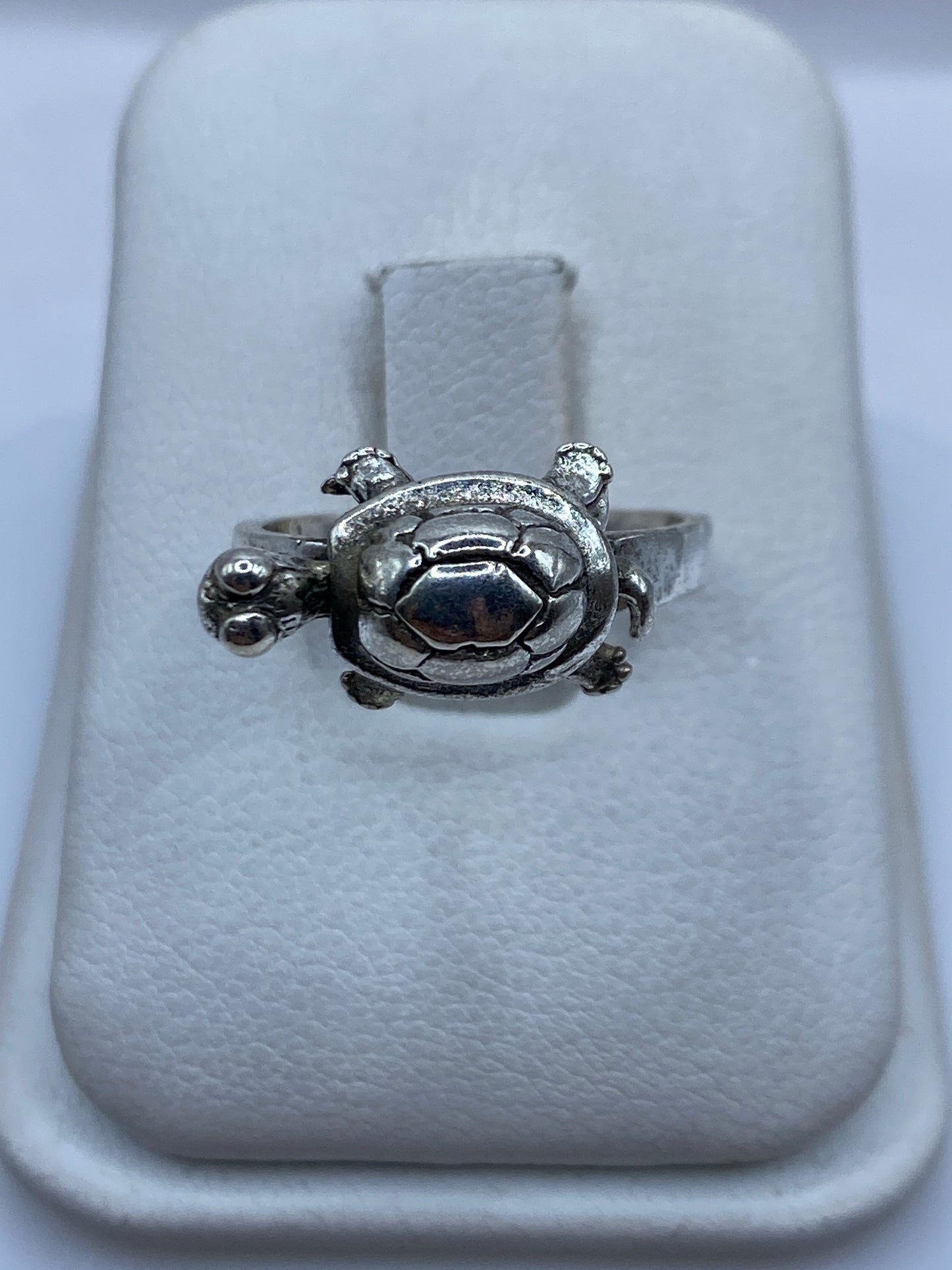 Anillo de plata tallado en forma de tortuga, símbolo étnico prehispánico, sobre blanco