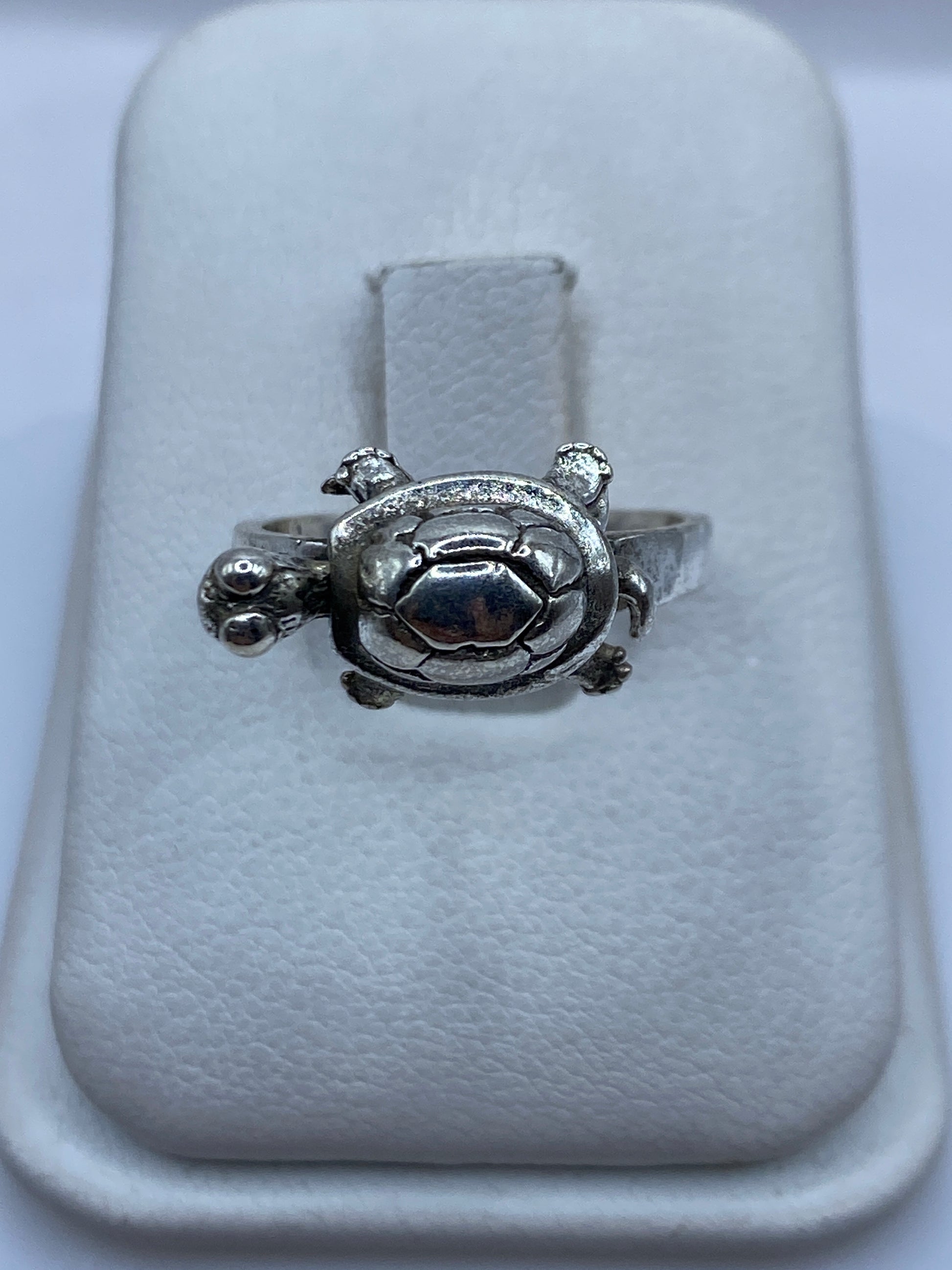 Anillo de plata tallado en forma de tortuga, símbolo étnico prehispánico, sobre blanco