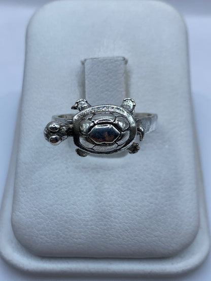 Anillo de plata tallado en forma de tortuga, símbolo étnico prehispánico, sobre blanco