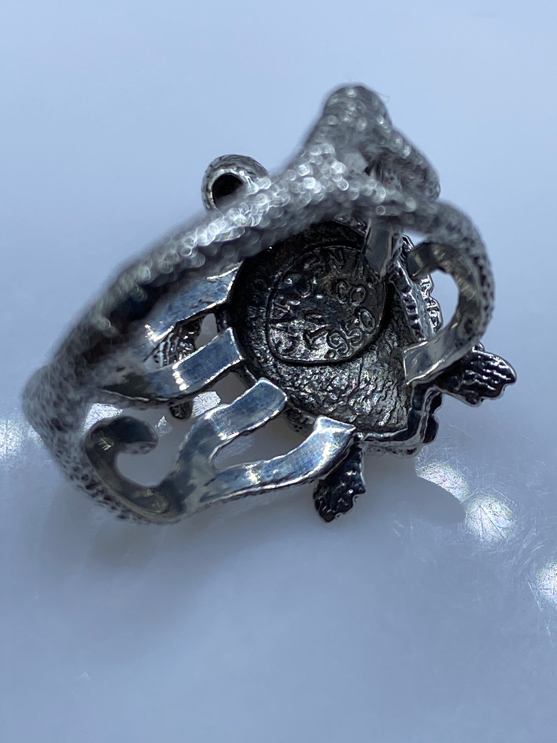 Anillo étnico sobre fondo gris mostrando el acabado pulido de la plata