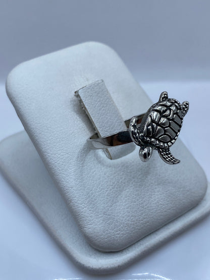 Anillo tortuga en la mano de una mujer, mostrando el tamaño real y acabado brillante