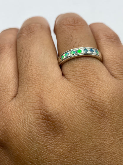 Anillo unisex en mano mostrando el cambio de color azul del ópalo bajo luz natural