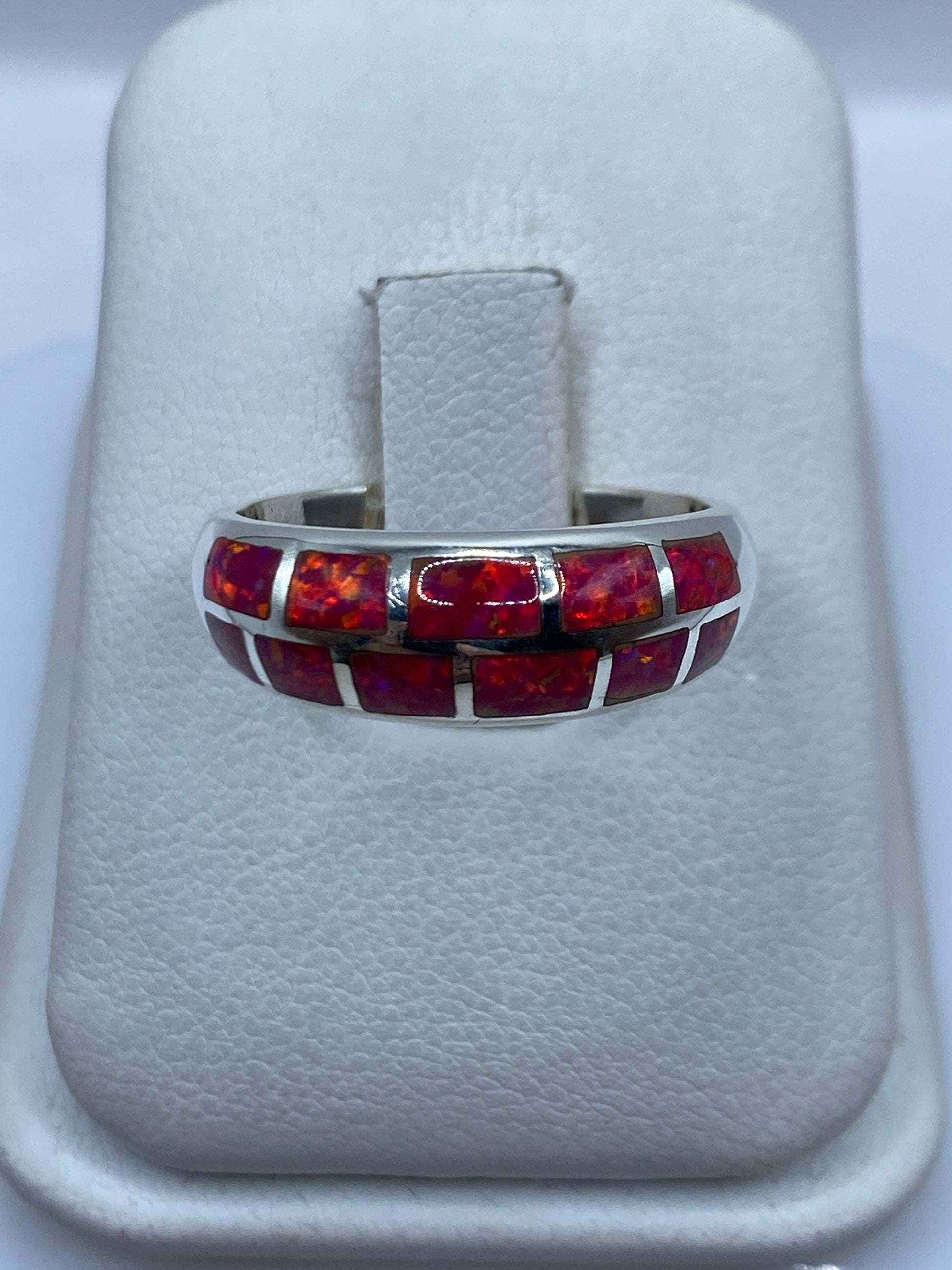 Anillo de plata .950 con ópalo de fuego rosa en banda pulida, visto desde arriba en estuche blanco