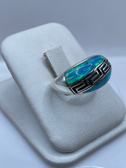 Ópalo de fuego color azul cielo con destellos verdes en detalle frontal del anillo