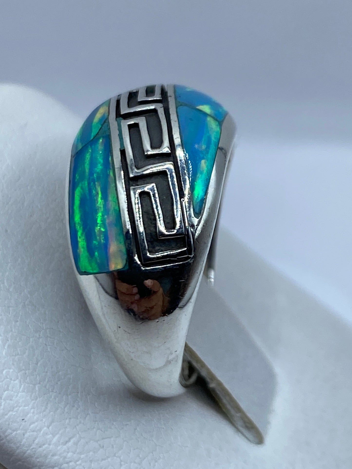 Anillo en mano mostrando el juego de colores del ópalo natural
