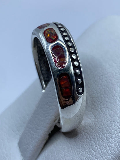 Anillo de ópalo multicolor en dedo mostrando el fuego natural de la piedra a la luz