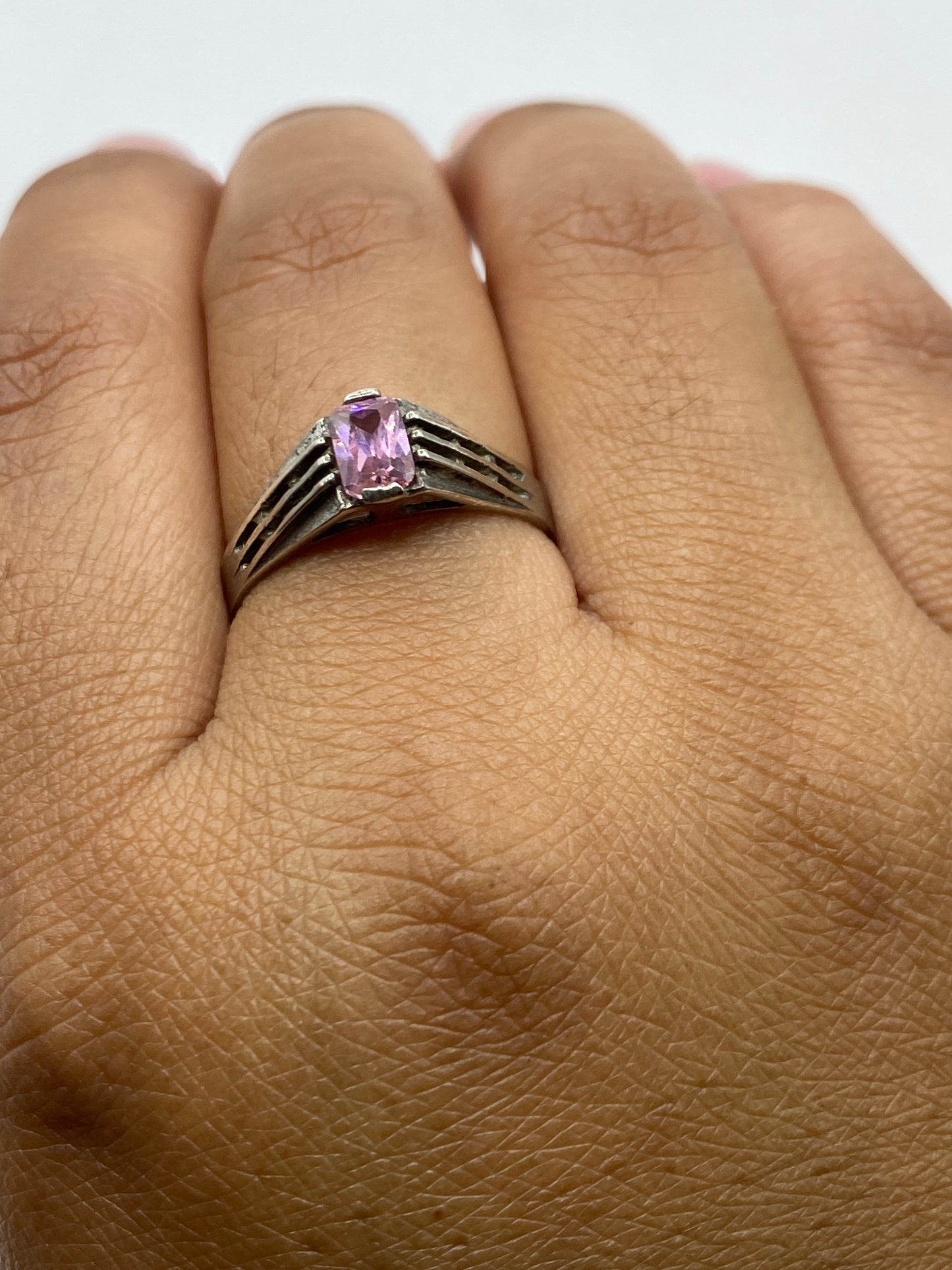 Anillo en dedo mostrando el brillo y presencia de la piedra rosa