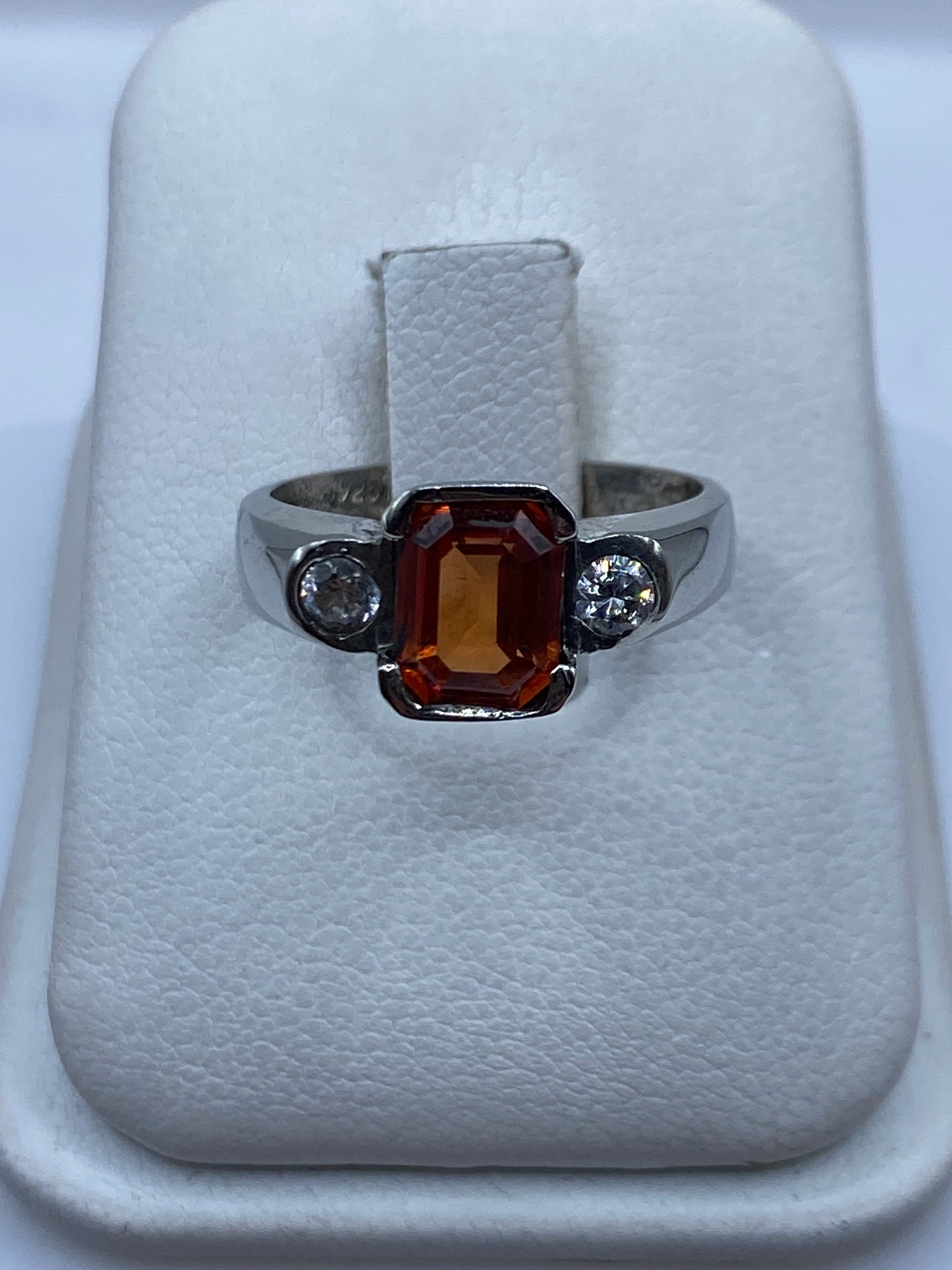 Anillo de plata solitario con circonia ámbar en caja blanca mostrando el frente