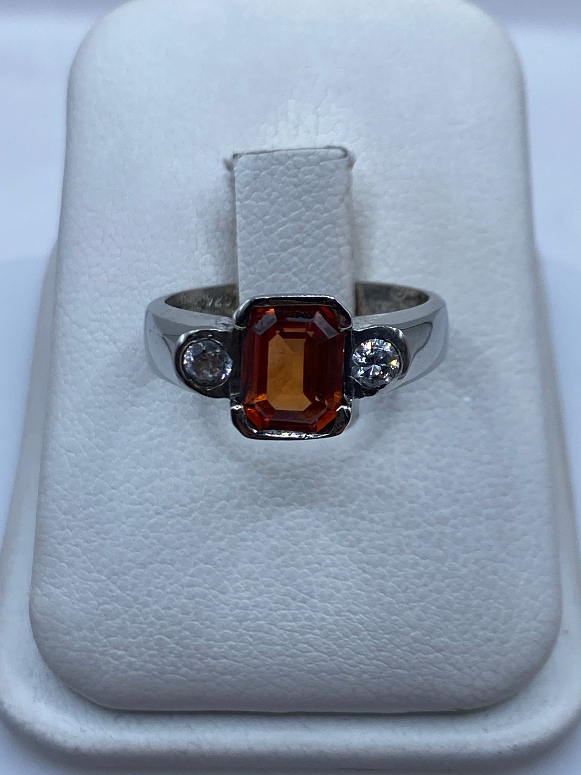 Anillo de plata solitario con circonia ámbar en caja blanca mostrando el frente